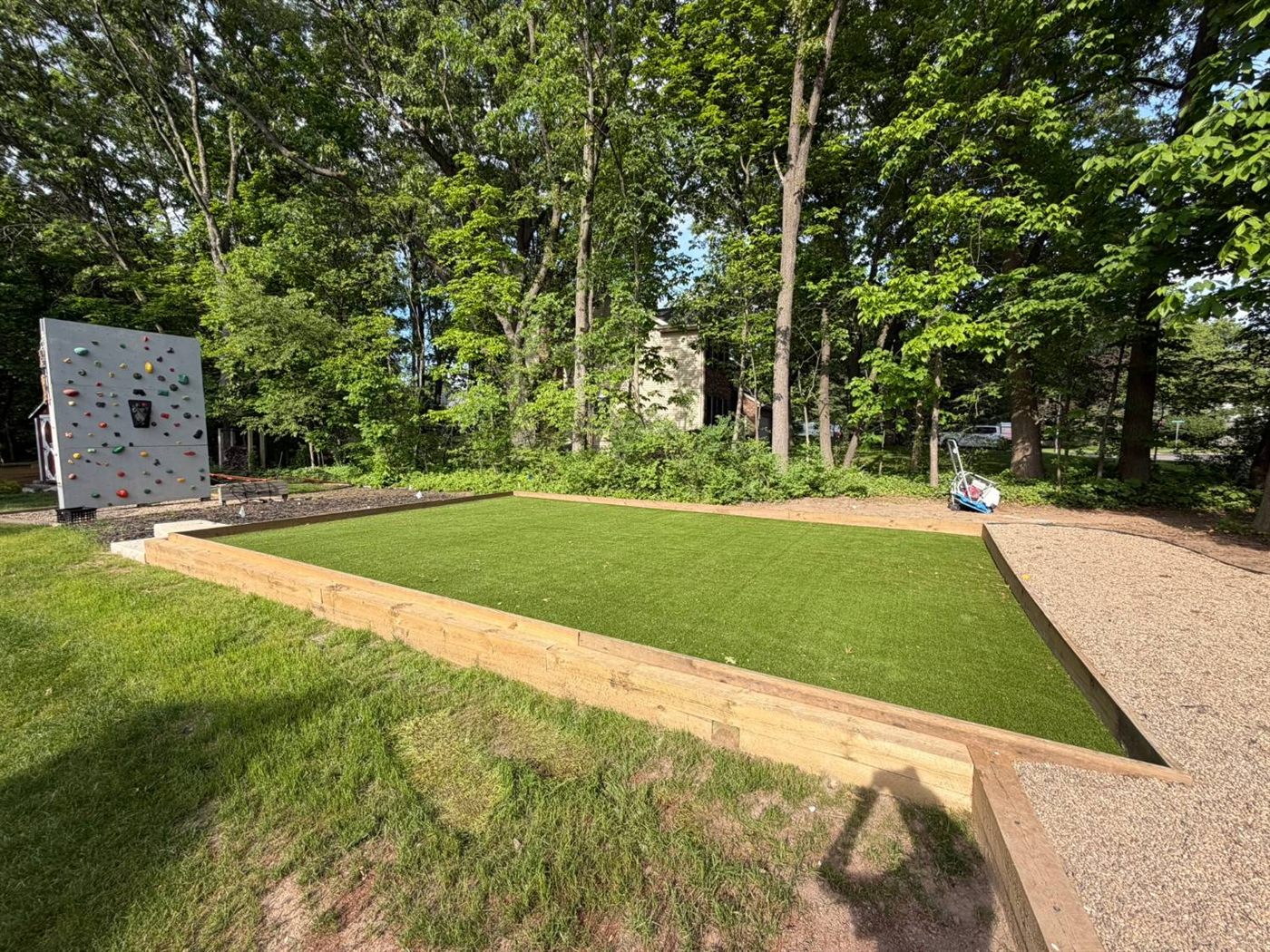 Artificial turf play area framed with timber borders and gravel