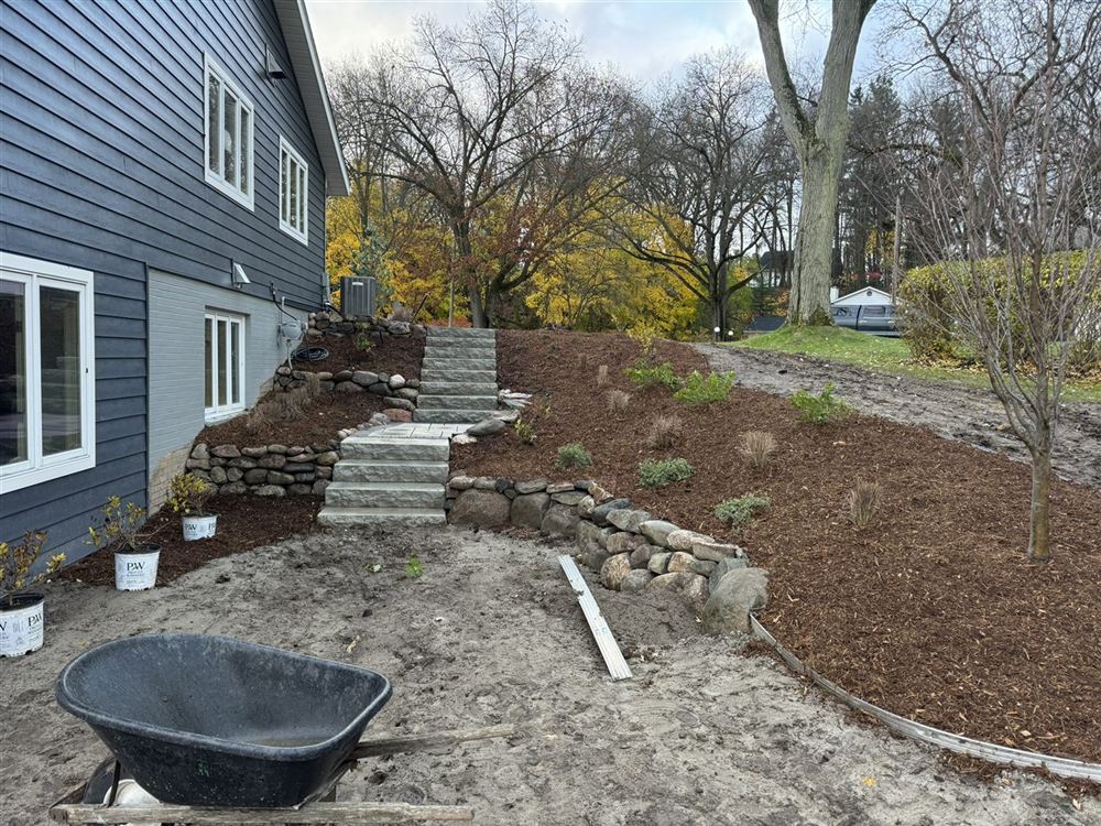 New stone steps, retaining wall, and mulched planting beds