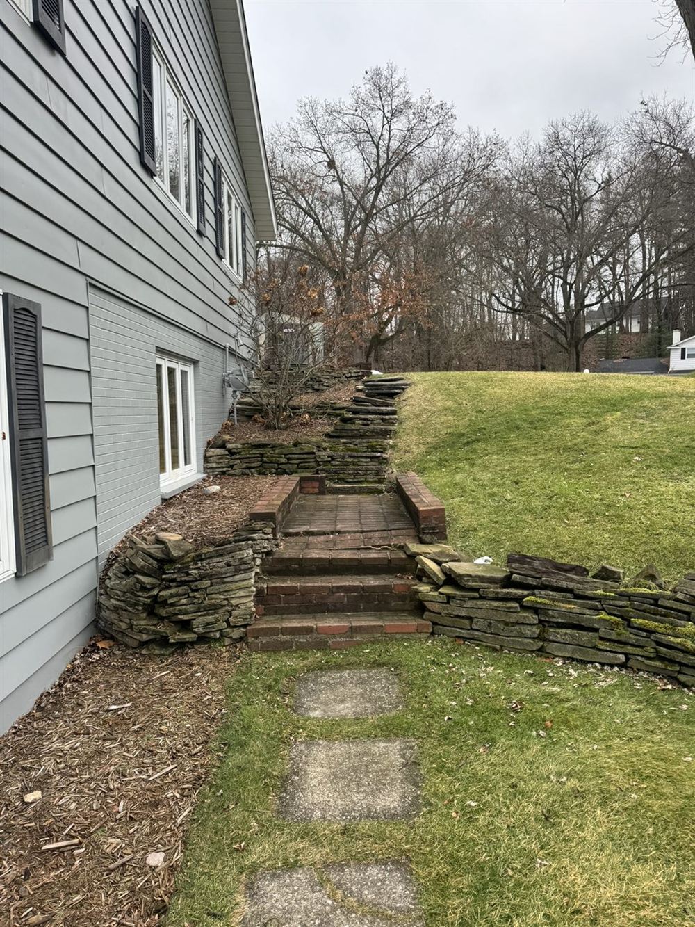 Old worn brick steps and stone wall before renovation