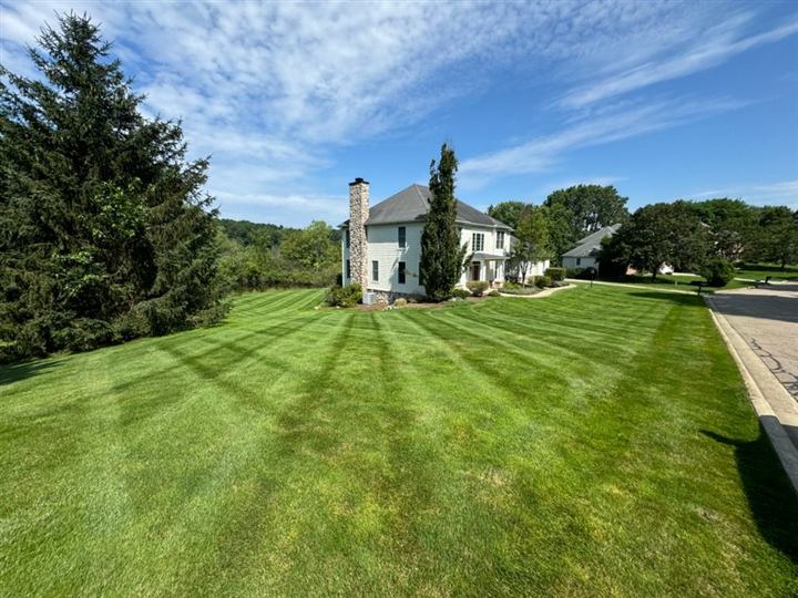 Wide striped lawn in front of a large home