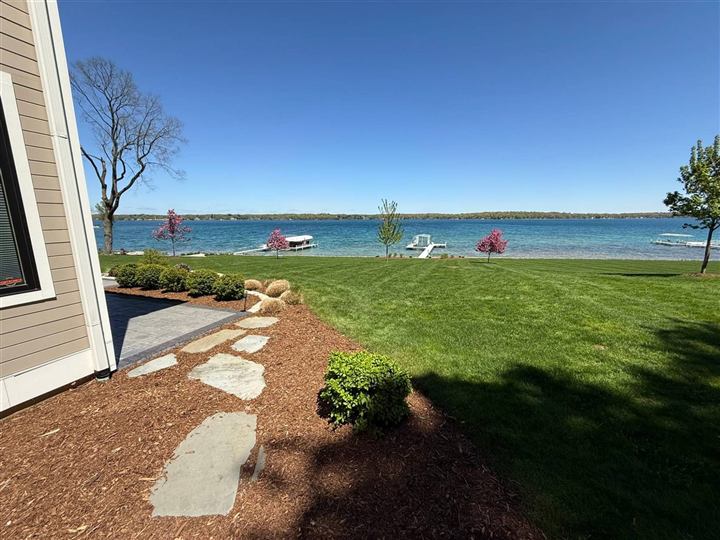 Mulched beds and flagstone path leading to a striped lawn on the lake