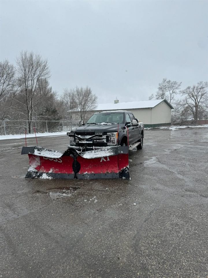 Plow truck clearing a snowy lot
